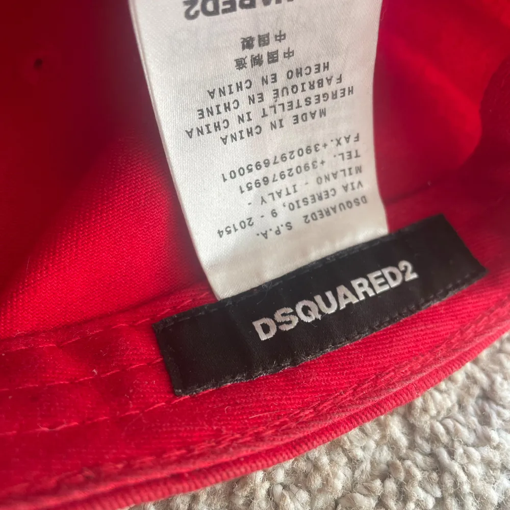 En röd keps från DSQUARED2 med texten 'COOL' i vita bokstäver på framsidan. Köpt på nk i vintras och inte använt mycket sen dess (skick 9,5/10). Nypris: 1799 Meddela mig för frågor!. Accessoarer.