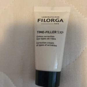 Filorga Time-Filler 5XP - Filorga Time-Filler 5XP är en korrigerande kräm för alla typer av rynkor. Produkten kommer i en vit tub med svart lock och är avsedd för att minska synligheten av rynkor.