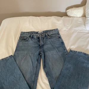 Blå jeansbyxor - Ett par blå jeansbyxor från Gina . Byxorna har en klassisk design med fem fickor och knappgylf.
