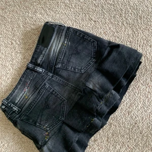 Svart lågmidjad jeanskjol med volanger - Det står att den är för 8 år, men skulle säga att det passar som en 134-140. 