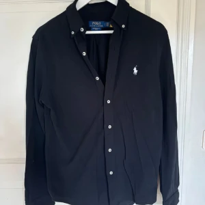Ralph Lauren Skjorta  - Ralph Lauren skjorta i svart. Inga defekter. Storlek S men kan även passa M. Har du någon fler fråga hör av dig! mvh Nordic Exchange