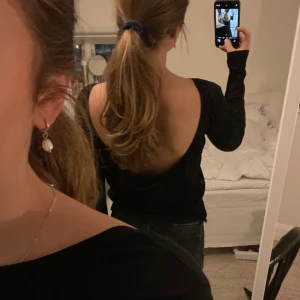 Topp med öppen rygg  - Säljer denna långärmade svarta toppen med öppen rygg från Nakd i storlek xs!💗