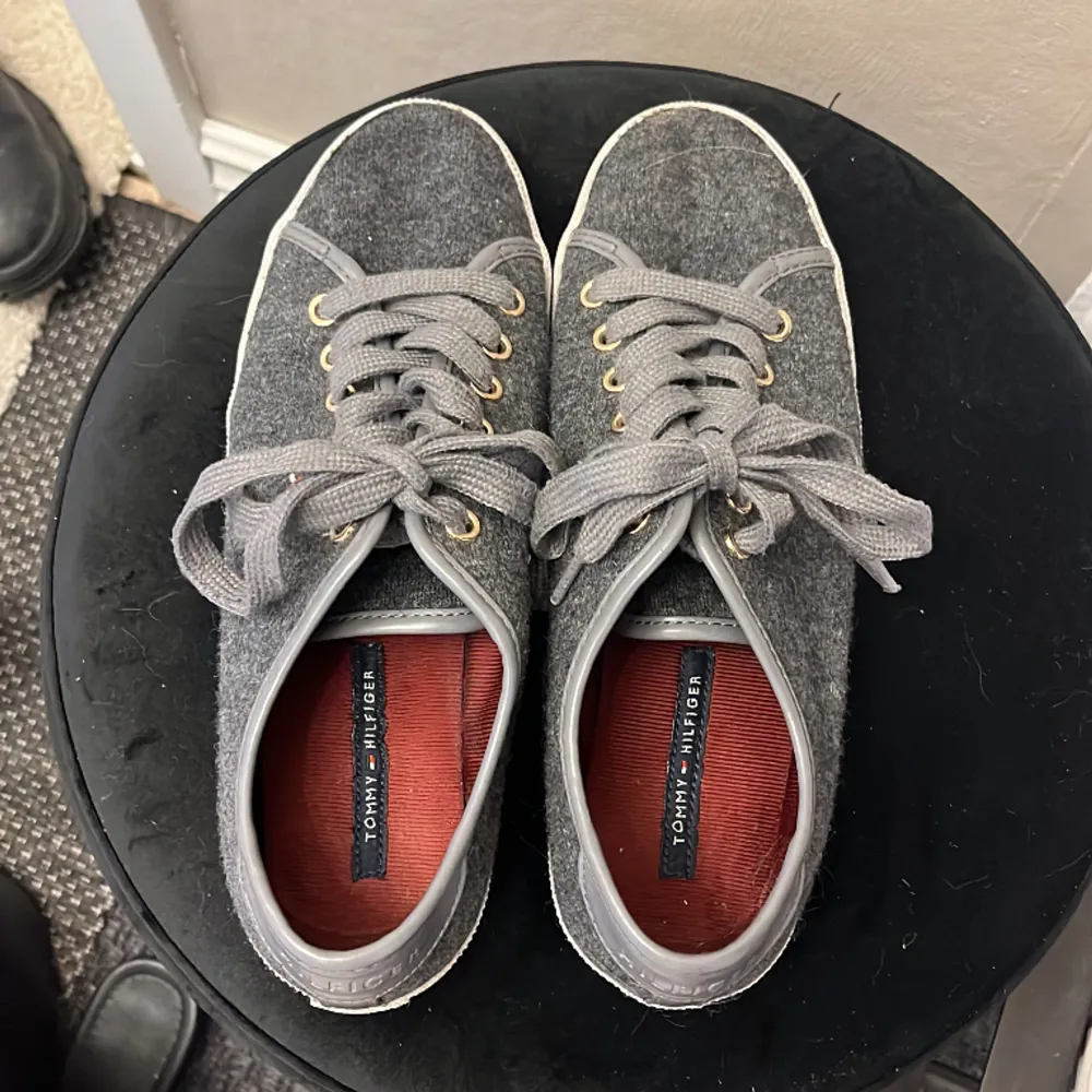 Sååå snygga låga skor från Tommy Hilfiger i perfekt grå färg. Ena skosnöret har tappat sin plastgrej längst fram (se bild 3), annars i gott skick! Skosnöret går enkelt att byta ut om man vill.. Skor.