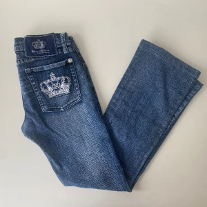 Victoria Beckham jeans - Lågmidjade bootcut Victoria Beckham jeans med vit krona och palieter. Jätte snygga, köpte de på plick men de passade inte. Midja: 36 cm    Innerbenslängd: 76cm    Skirv gärna om ni har frågor👑
