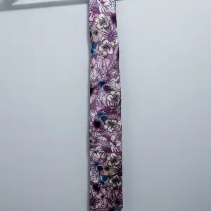 Flerfärgad, blommig Amanda Christensen-slips i nyskick. Bredd 8 cm.  Nypris: 750 kr  Hämtas på Ön i Malmö eller skickas per post.