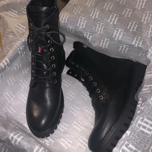 Tommy Hilfiger kängor  - 1 år gamla, knappt använda  Nypris 2000 kr   Flärpen på ena gick av när jag drog lite hårt, se bild, inget som syns eller stör dock då det går att lägga innanför skon