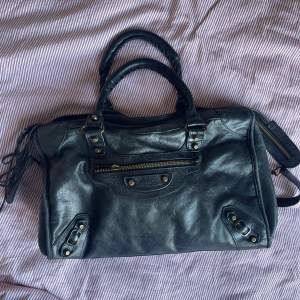 Säljer min balenciaga liknande väska, i äkta skinn. Absolut sliten och saknar spänne vid dragkedjan men går lika bra att öppna ändå! Har också det långa bandet man kan ha crossbody!