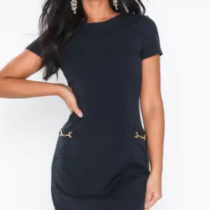 En svart Klänning NWT, Figurnära modell, Vävd kvalitet, Rund halsringning, Kort ärm,Fickor framtill med guldmetall dekoration 🌸material: polyester 