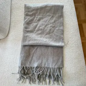 Ljusgrå halsduk med fransar från Ginatricot.  Använd men superfint skick🙌🏼!  Fin till alla årstider 💕
