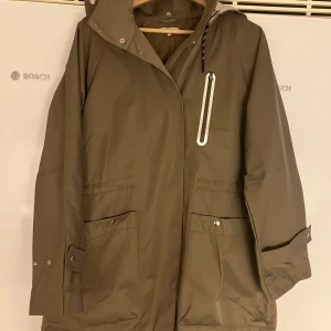 Filippa K soft sport parkas  - En vatten och vindavisande  tunn parkas .  Mullvads brun/ grå  med silverdetaljer. Borttagningsbar luva . Small  känns lite oversize  