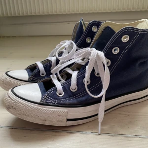 Marinblå converse - Superfina marinblå converse i hög modell. Perfekt till sommaren, sparsamt använda och har bara några enstaka fläckar på den vita kanten, annars i väldigt bra skick. Nypris ca 700kr
