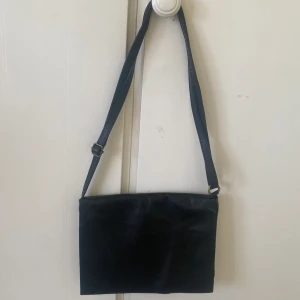 Svart tunn väska - Läder material i tunn form. Oanvänd. 