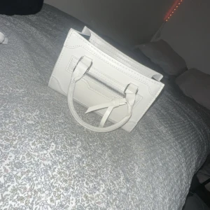 Vit väska - Fin väska aldrig andvänd, kommer med band som man kan spänna fast. 