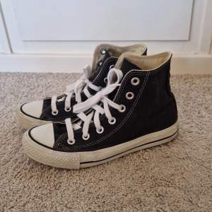 Svara höga Converse skor . Använda men i bra skick , man ser i sulan att de är använda då liten del av texten är borta . De har nya vita snören också 
