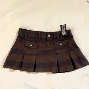 Rutig kort veckad kjol - Midjemått: 80cm. Från humana 170kr.  Lite förstor för mig som vanligtvis är en small.