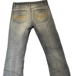 Lågmidjade jeans med tryck - Jeansen har tryck på fickorna där bak , har en bra passform och är utsvängda längre ner vid benen. De passar bra i längden på mig som är ca 160 :)   Köparen står för frakten🫶