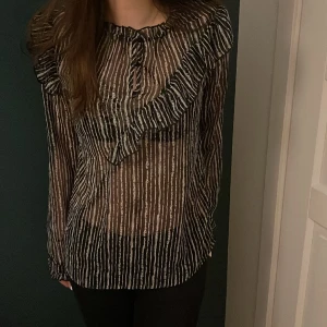 Blus  - Fick denna blus men är inte riktigt min stil så vill sälja vidare den. Svartvit randig med volanger och ganska genomskinlig. Blusen är ifrån culture.