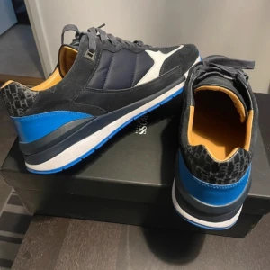 Hugo Boss sneakers i skinn - Stl. 42.  Endast provade 2 ggr. Dom är tyvärr för stora för mig. Inköpta i Köpenhamn av mig för 1.799 DKR (Drygt 3.000 SEK) för 1,5år sedan. Väldigt snygga.