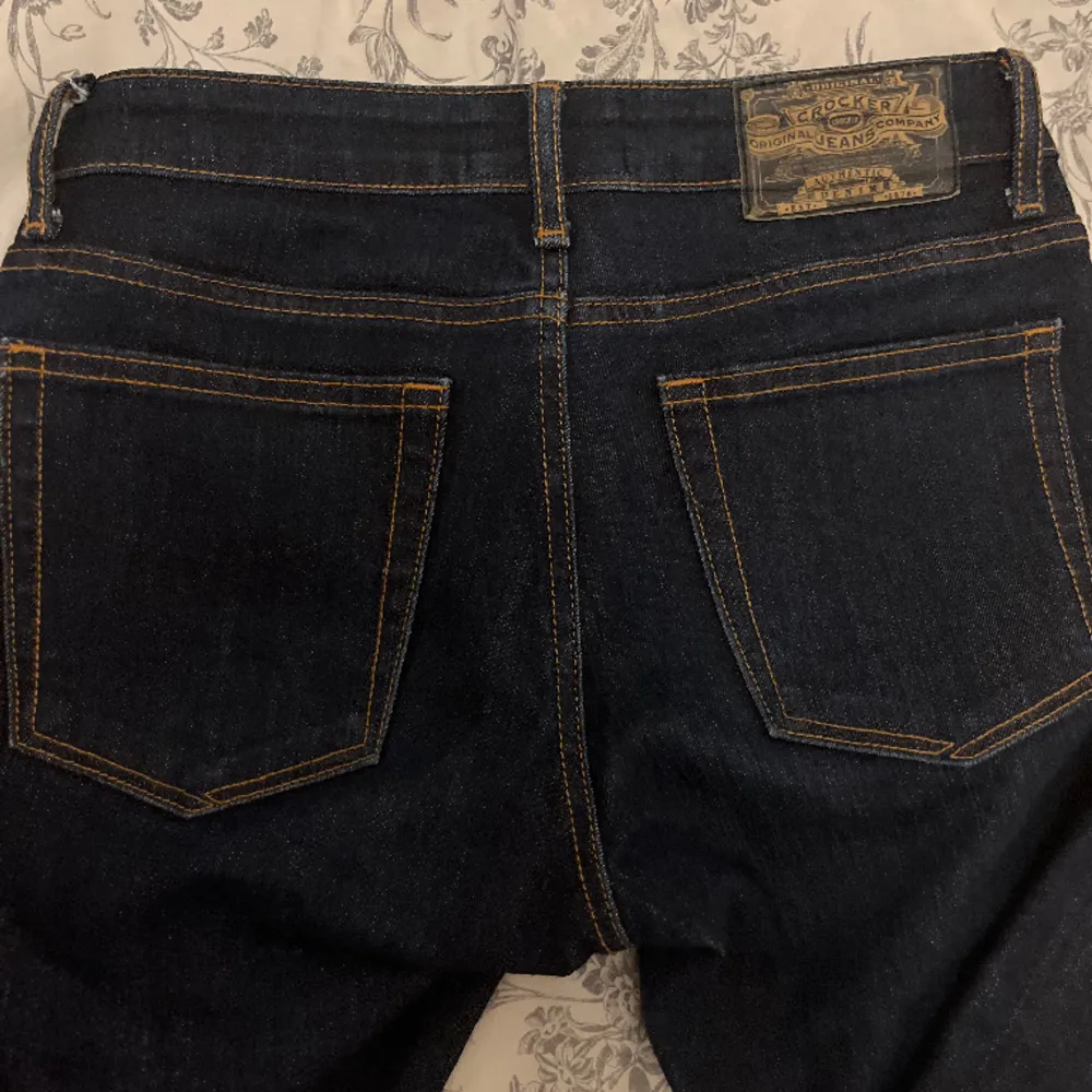 Hej!!  Säljer dessa skit snygga mörkblåa bootcut jeans från märket crocker jeans. De är låg midjade och har ljusbruna sömmar och jeansen är i storlek 27 längd 35. Säljer dessa då dom är för långa och jag är 163🤎🪩. Jeans & Byxor.