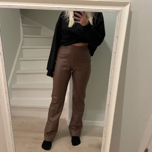 Bruna läderimitation byxor  - PU- byxor i brun från NLY trend, har dragkedja på ena sidan och är lite utsvängda. Sååå sköna, men kommer ej till användning tyvärr. Nyskick !