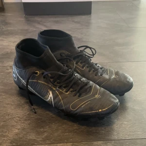 Nike fotbollsskor - Fina svarta Nike fotbollsskor i storlek 45, väldigt fina finns dock en skada (bild 3) pris kan diskuteras och kan även skicka fler bilder vid smidig affär