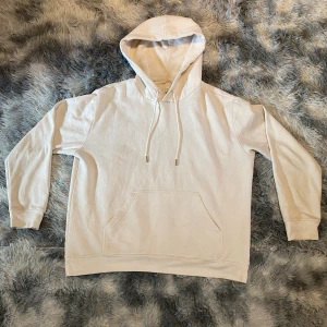 Vit Hoodie - Säljer en stilren och snygg hoodie i toppskick. Den har inga skador eller fläckar och är riktigt bekväm. Skick: 10/10. Stl 170-180. Skriv gärna vid frågor🤗 Fraktas inom 48h📦