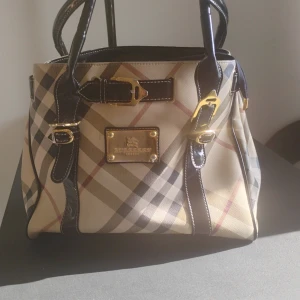 Burberry väska - Jättefin Burberry handväska, flera fack inuti, är i väldigt fin form knappt använd