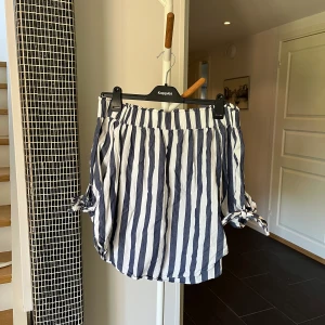 Bluse  - Det är en blåvit off shoulder bluse. Det finns snören på siderna som man kan knyta till rosetter. :) 