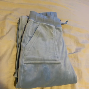 Ljusblåa Juicy Couture Byxor - Säljer ljusblå juicy couture byxor i storlek xxs. Köpta här på Plick för ett tag sedan men har inte använt de mycket. Hyfsat bra skick men lite missfärgning längst ner på byxbenen. Skriv för frågor eller fler bilder💞