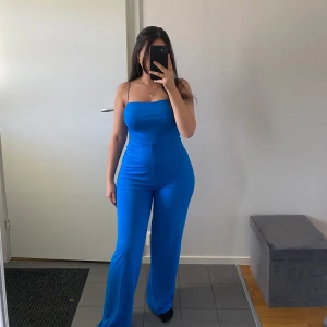 Zara jumpsuit - En blå jumpsuit från Zara som är köpt i Estland för 2 år sen. Den har en öppning på båda sidorna som man kan se på andra bilden. Endast använd en gång och är som ny. Passar storlek S