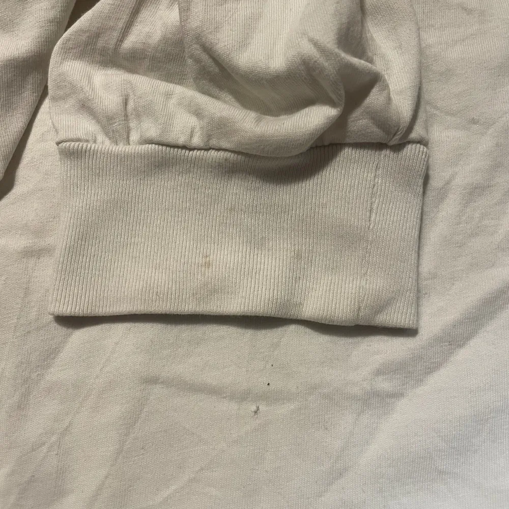 Långärmad i t-shirt material vit vans tröja med tryck i storlek large/L, i använt skick där man ser på sista bilden ett litet litet hål ifrån larmet som satt på i butik och små fläckar på mudden vid handen som också finns på bild nmr 3. T-shirts.