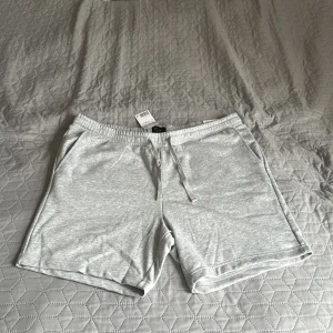 Grå Shorts - Helt nya oanvända shorts från H&M. De går ner till knäna ungefär, storlek XL