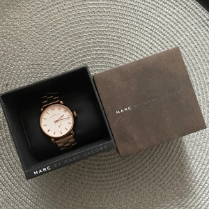 Marc jacobs klocka roséguld MBM 3244 - Äkta Marc Jakobs klocka i roséguld. Sparsamt använd, behöver nytt batteri då den legat i garderoben ett par år. Fungerar utmärkt annars. Extra länkar finns så man kan justera storleken. 