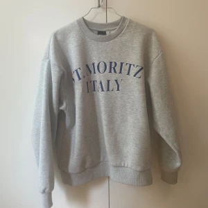 Grå collegetröja | Gina Tricot - Grå collegetröja från Gina Tricot med ett fint tryck på framsidan. Tröjan är använd väl, men ändå i bra skick! Tryck gärna på ”köp nu” och kontakta mig vid frågor, fler bilder, m.m❣️