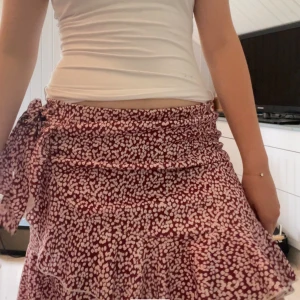 Mini omlottkjol med rosett - Supersöt sommarkjol med volang och omlott design.  Resårband med stretch i midjan där du kan knyta åt en rosett 🎀