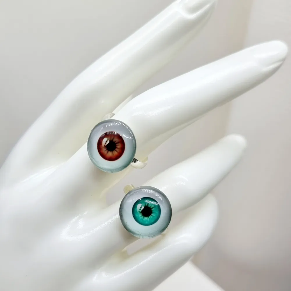 Unik ring -öga●👁● Material: metal, glas.Stommen är ca 12mm i diameter, men kan göras mindre eller större, efter behov. Det är bara att försiktigt klämma ihop eller dra isär ändarna baktill, till önskad storlek. . Accessoarer.