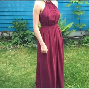 Vinröd långklänning till bal eller liknande, använd vid ett tillfälle, därav är skicket som ny!!  Storlek 34, jag är 164cm lång. Från Nelly.com
