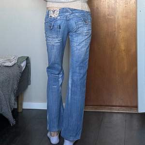 Jättesnygga lågmidjade jeans i mycket bra skick från märket musketeer. De är använda bara ett par gånger och nästan som nya! De har coola detaljer på både fram och bakficka och är mycket lowwaist! Innerbenslängd 75cm midjemått 37,5cm