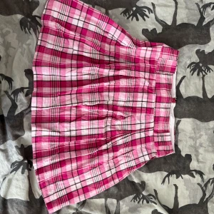 Rosa rutig kjol - Fin kjol med bra kvalitet. Fick den av min mamma som hade den under 90talet. Jag har sytt in den lite men det går att sprätta upp om man vill ha den större. Storlek innan var 36-38 men nu uppskattar jag den som XS/S