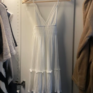Sommarklänning - Säljer denna somriga vita klänningen som jag köpte förra året men glömt bort och har därför lappen kvar, passar perfekt till avslutning eller student, korsad i ryggen och strechigt material❤️