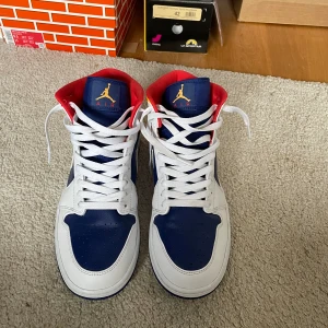 Jordan 1 mid laser orange deep royal blue - Ett par Jordan 1 Mid som är i sjukt bra skick! Tyvärr finns det ingen låda då jag slängde den för jag tänkte inte att det var något viktigt. Har kvittot på mail och de är köpta från Restocks. Kan skicka bild på kvittot om det önskas. 