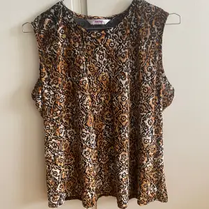 Oanvänd blus/linne i nyskick köpt på beyond retro. Jättesnyggt mönster, ser nästan ut som leopard mönster. Asskönt material och bra passform! 