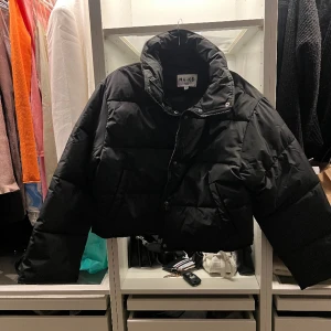 Vadderad jacka - Kortare vadderad jacka från NA-KD. Köptes nyligen för en månad sen, drog bort lapparna direkt men har bara använt den en gång. Helt ny. Jättesnygg vår/ höst jacka som sitter perfekt för mig som är en S, passar mindre/ större med. 