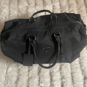 Vintage prada duffle bag - Prada 40L duffle bag! Riktigt snygg väska som är inköpt av min pappa i Milano men finns dessvärre inget kvitto kvar. Den är sparsamt använd och i gott skick, Hör av er vid frågor!