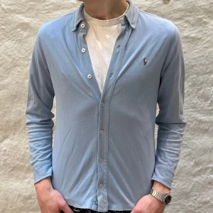 Ralph Lauren skjorta - Ralph lauren skjorta i färgen blå. Storlek 14-16 (passar XS) och modellen är 178 cm. Nyskick, inga skavanker. Nypris 1699kr kr, köp för endast 599kr.