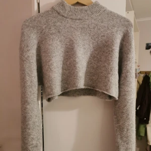 Stickad ull-magtröja  - Grå magtröja från Monki i storlek XXS. 🦦 Använd max 3 gånger, den är värmande och sitter fint på en långklänning 😋