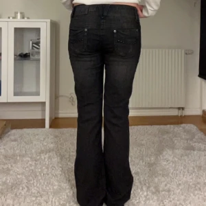 Lågmidjade jeans - Svarta lågmidjade jeans. Midjemått 82 cm. Innerbenslängd 84 cm.