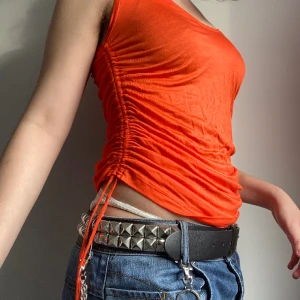 Orange topp - Topp med drawstring på sidan, kan bäras som kort klänning om man är kortare än mig (168 cm). Sparsamt använd, inga synliga defekter. Hör gärna av er vid frågor!