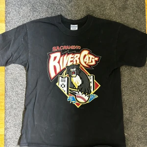 T-shirt med tryck - Riktigt fet T-shirt med tryck, på trycket står det ”Sacramento rivercats” säljer då den är lite för stor och används inte längre. Ställ gärna frågor! 😁👍