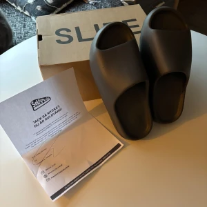 Svarta yeezy slides  US 11 - Säljer ett par svarta yeezy slides. De är använda men i bra skick  och kommer med originalförpackning.  köpta på soleplus för 2000kr . . man får med boxen . Storleken är US 11 som motsvarar 46 men dom är väldigt små i storleken så passar dig som har 44-44,5